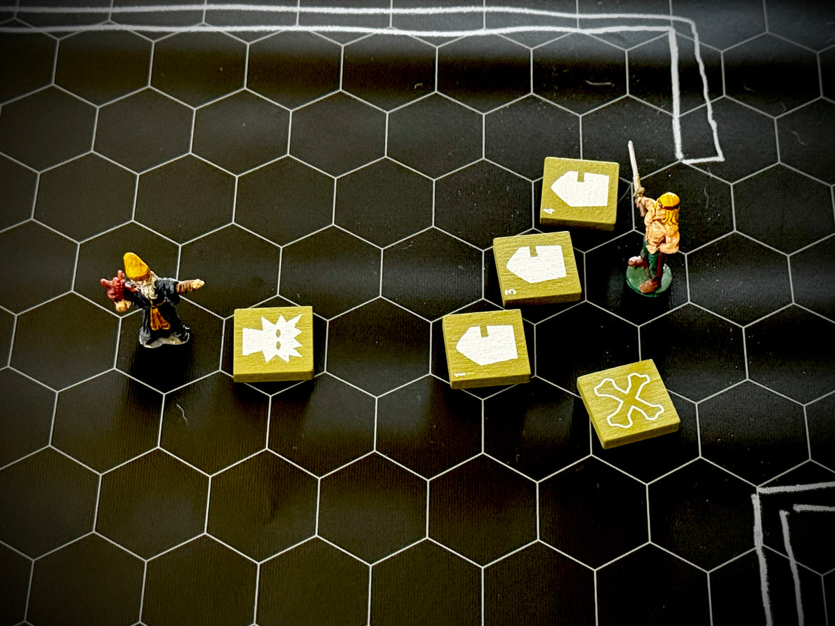 Hex mat with two miniature figure and several  green QuoDrox tiles. 